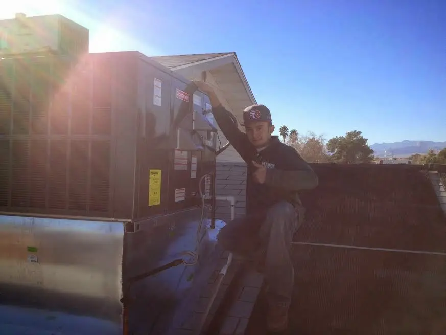 HVAC technician performing AC Tune-Up on a rooftop unit in Beaver Dam